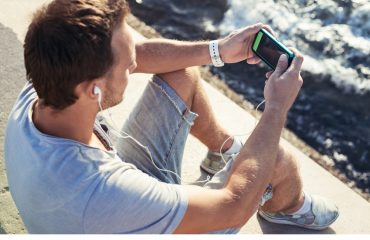 mobile smartphone in man's hands near the sea
